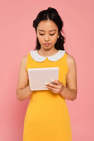 Asiatka Žlutých Šatech Pomocí Digitální Tablety Izolované Růžové — Stock fotografie