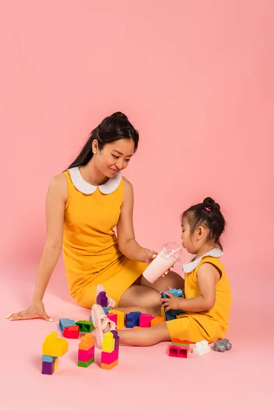 Щаслива Азіатська Жінка Дочка Сидячи Граючи Будівельні Блоки Рожевому — стокове фото