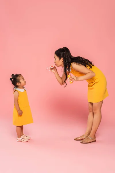 Full Length Asian Mother Blowing Soap Bubble Toddler Daughter Pink — Stock Photo, Image