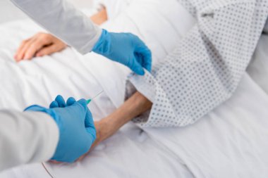 Hemşirenin elinde yaşlı bir hastanın yanında damar içi terapi iğnesi tuttuğunu gördüm. 