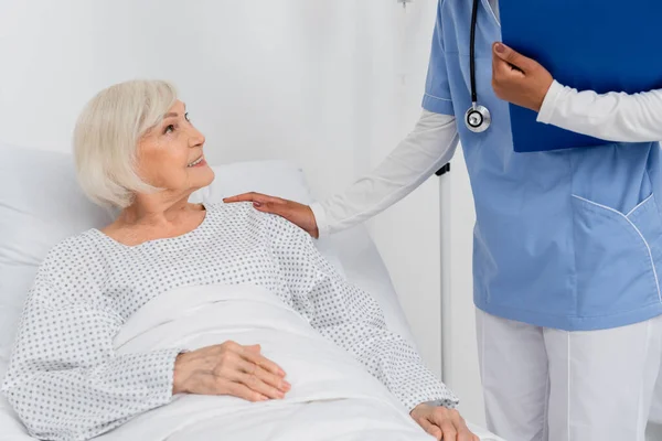 Mujer Anciana Sonriente Mirando Enfermera Afroamericana Con Portapapeles Sala Hospital — Foto de Stock