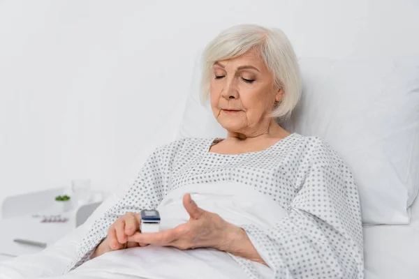 Senior Woman Using Digital Oximeter Blurred Foreground Hospital — Stock Photo, Image