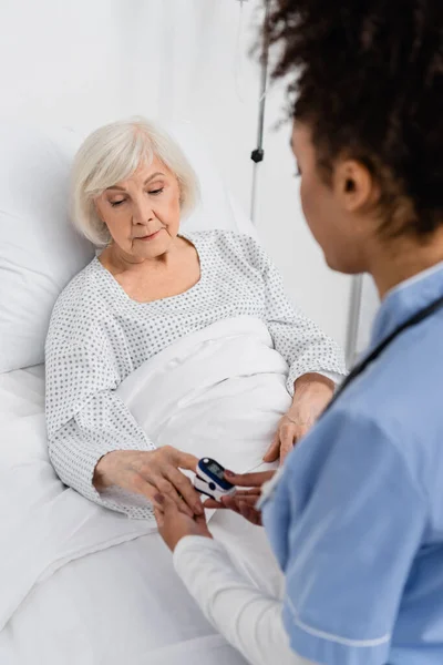 Mujer Mayor Usando Oxímetro Digital Cerca Enfermera Afroamericana Sala Hospital — Foto de Stock