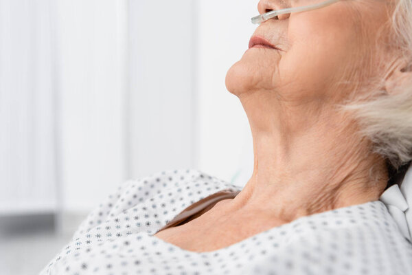 Cropped view of senior patient with nasal cannula in hospital ward 
