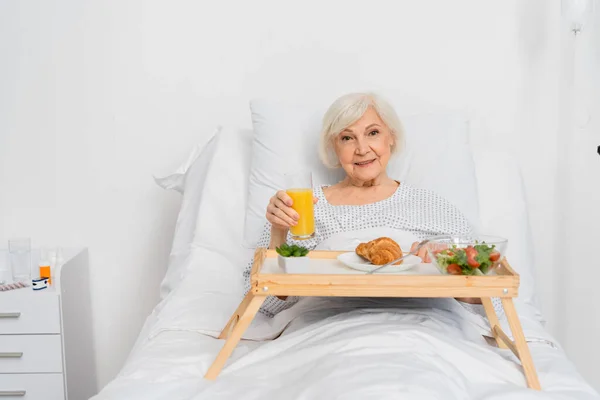 Paciente Mayor Sosteniendo Jugo Naranja Cerca Comida Bandeja Hospital — Foto de Stock