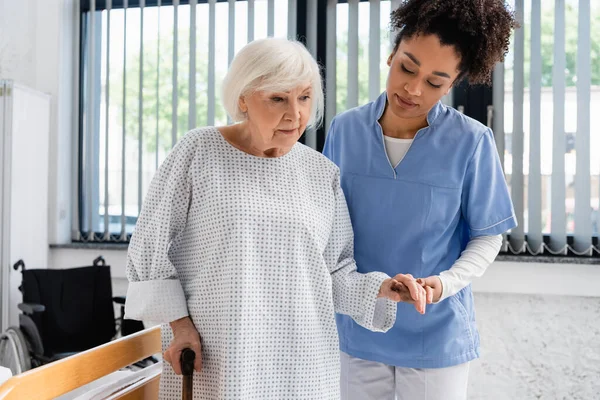 African American Nurse Holding Hand Patient Walking Cane Clinic — Stock Photo, Image