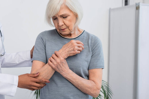 Африканский американский врач, стоящий рядом с женщиной, касающейся руки 