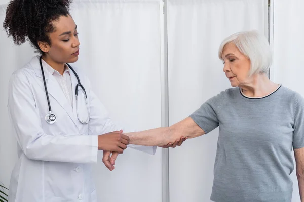 Afroamerikanischer Traumatologe Untersucht Arm Einer Patientin Krankenhaus — Stockfoto