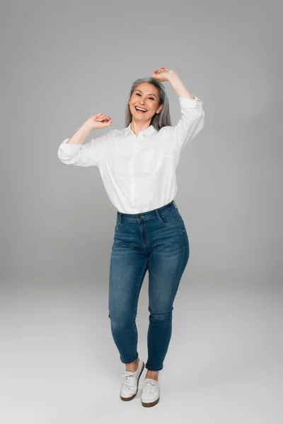 Joyful Asian Woman Jeans White Shirt Showing Yeah Gesture Grey — Stock Photo, Image