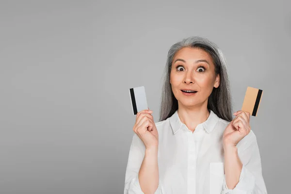 Amazed Asian Woman Grey Hair Showing Credit Cards Isolated Grey — Stock Photo, Image