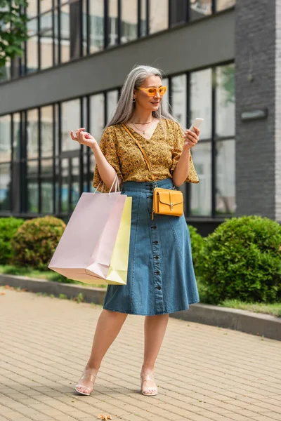 Trendy Asian Woman Shopping Bags Using Smartphone City Street — Stock Photo, Image