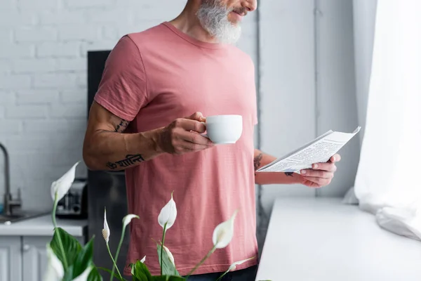 Cropped View Mature Man Holding Newspaper Cup Kitchen — Stock Photo, Image
