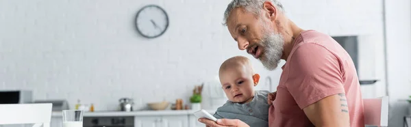 Mature Father Holding Smartphone Baby Daughter Kitchen Banner — Stock Photo, Image