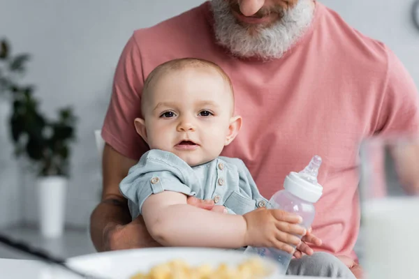 Babymädchen Mit Flasche Blickt Kamera Neben Vater — Stockfoto