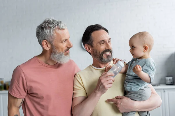 Gülümseyen Homoseksüel Adam Yanında Çocuk Bebek Şişesi Tutuyor — Stok fotoğraf