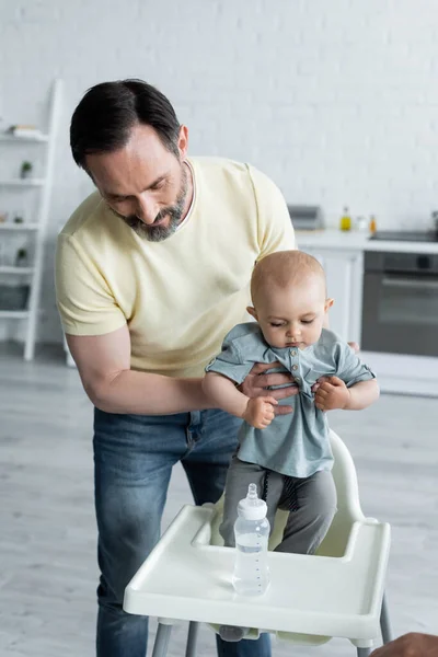 Homme Tenant Bébé Fille Près Chaise Haute Biberon Maison — Photo