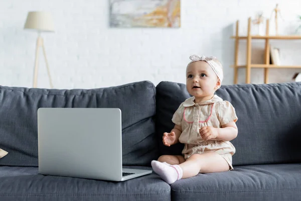 Criança Olhando Para Longe Perto Laptop Sofá — Fotografia de Stock