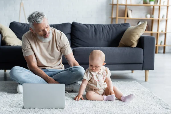 Kleinkind Sitzt Mit Laptop Auf Teppich Neben Vater — Stockfoto