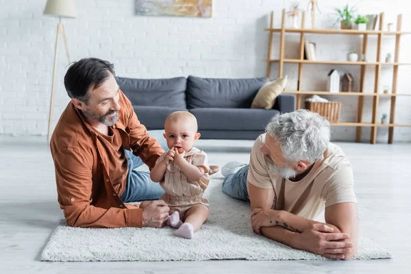 Glimlachend Homoseksueel Paar Liggend Buurt Peuter Dochter Tapijt — Stockfoto