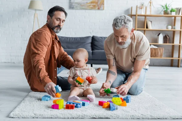 Homoseksuele Ouders Spelen Bouwstenen Met Dochter Tapijt — Stockfoto