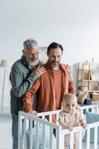 Homosexual Man Hugging Partner Baby Daughter Crib — Stock Photo, Image