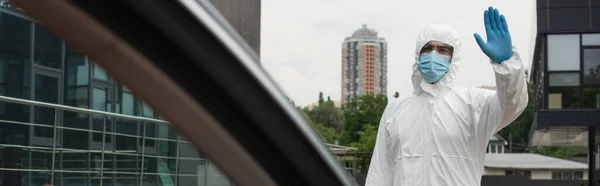 Trabajador Médico Traje Materiales Peligrosos Agitando Mano Cerca Coche Borroso —  Fotos de Stock