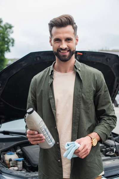 Conductor Sonriente Sosteniendo Trapo Aceite Motor Cerca Coche Borroso — Foto de Stock