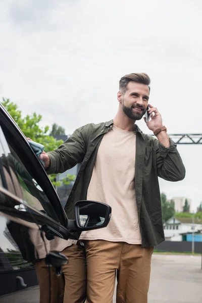 Motorista Sorrindo Falando Telefone Celular Enquanto Limpa Carro Livre — Fotografia de Stock