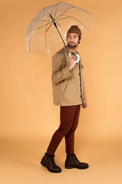 Young Man Jacket Brown Pants Looking Back While Walking Umbrella — Φωτογραφία Αρχείου