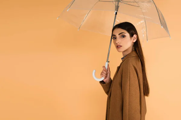 Pretty Brunette Woman Trendy Coat Looking Camera Umbrella Isolated Beige — Φωτογραφία Αρχείου