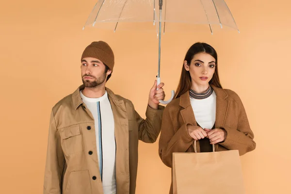 穿着夹克的男人 戴着雨伞的小便帽 遮挡着与米色隔离的时髦女人 — 图库照片