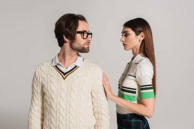 young couple lin stylish clothes looking at each isolated on grey