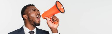 african american businessman in suit screaming in megaphone isolated on grey, banner clipart