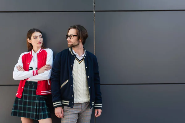 Young Couple Trendy Jackets Looking Each Other Grey Wall — Zdjęcie stockowe