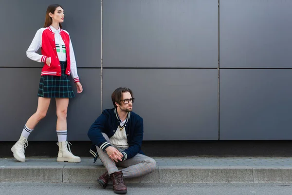 Young Couple Trendy Clothes Looking Away While Posing Grey Wall — Zdjęcie stockowe