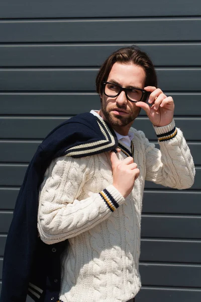 Stylish Man White Knitted Pullover Adjusting Eyeglasses While Looking Away — Foto de Stock