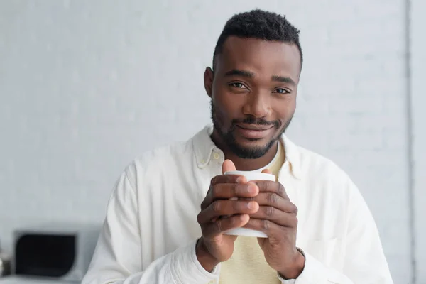 アフリカ系アメリカ人の陽気な男性が朝コーヒーを飲みながら — ストック写真