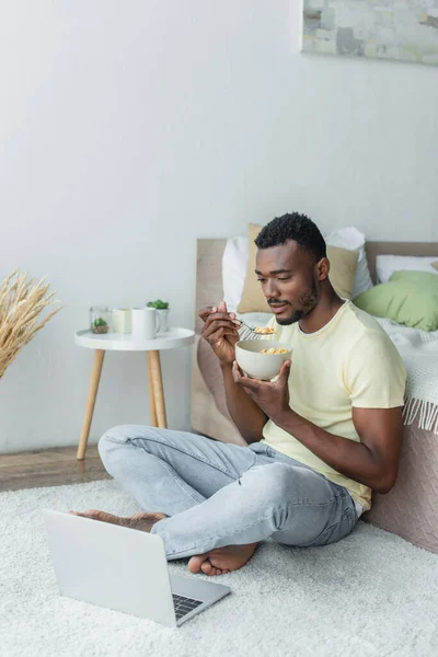 アフリカ系アメリカ人男性がベッドルームで朝食をとりながら — ストック写真