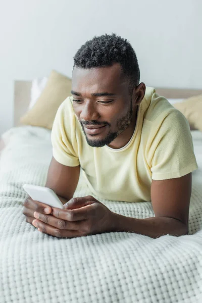 Homem Americano Africano Alegre Shirt Usando Smartphone Deitado Cama — Fotografia de Stock