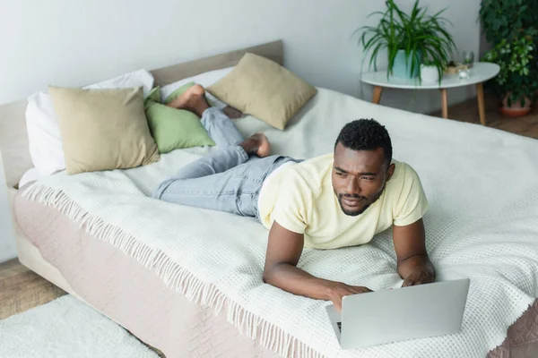 Freelancer Afro Americano Pensativo Shirt Usando Laptop Deitado Cama — Fotografia de Stock