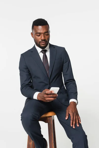 Hombre Negocios Afroamericano Traje Sentado Taburete Madera Uso Teléfono Inteligente — Foto de Stock