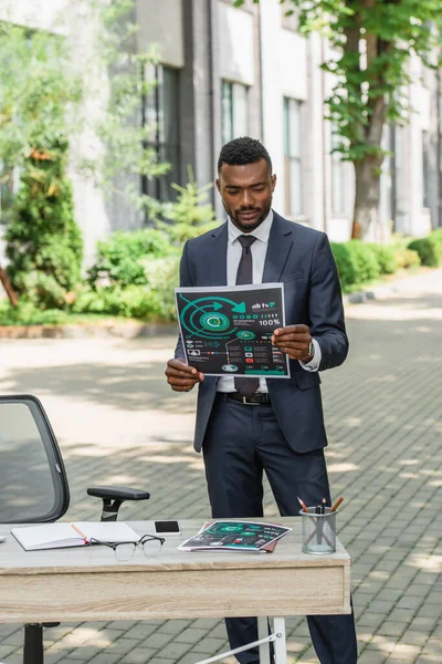 Empresario Afroamericano Sosteniendo Infografías Impresas Cerca Escritorio Afuera — Foto de Stock