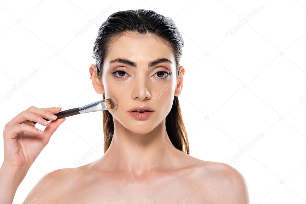 woman applying face foundation with cosmetic brush isolated on white