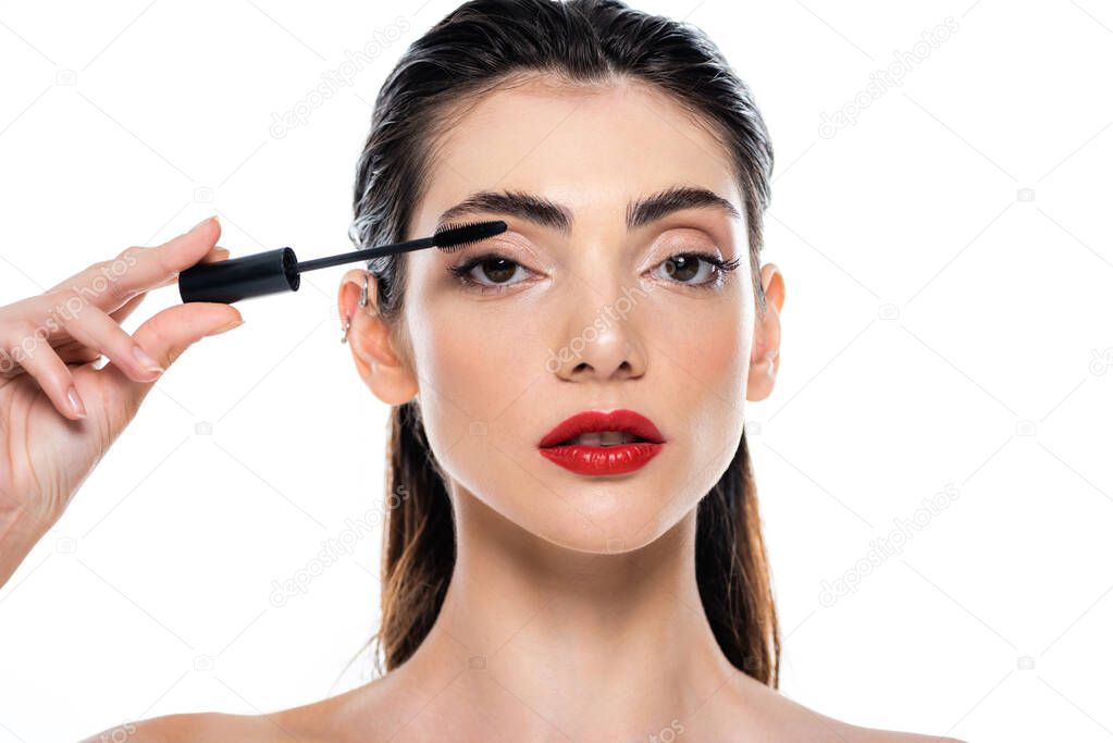 young woman applying mascara isolated on white 