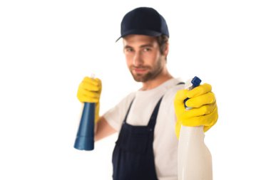Blurred worker of cleaning company holding detergents isolated on white  clipart