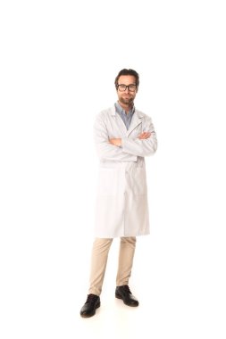 Full length of doctor standing with crossed arms on white background  clipart