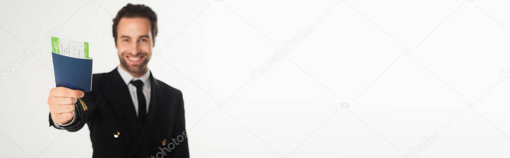 Passport and boarding pass in hand of blurred aviator isolated on white, banner 