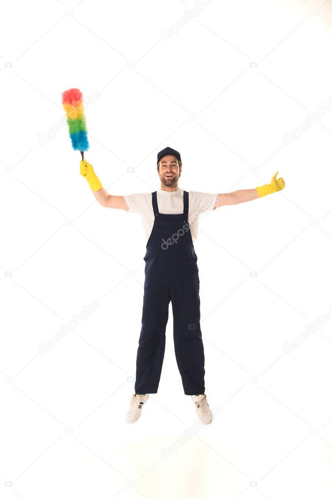 Excited cleaner with dust brush showing like while jumping isolated on white 