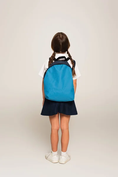 Rückseite Schulmädchen Mit Blauem Rucksack Steht Auf Grau — Stockfoto