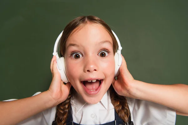Excited Schoolkid Open Mouth Touching Headphones While Standing Chalkboard — Stock Photo, Image